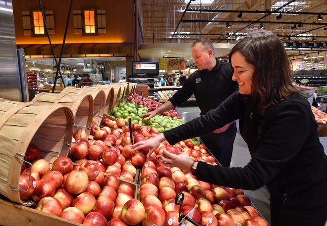 Jeff Benjamin and Katie Barbone organize a display in the produce section inside Wegmans at the at the Meadow Glen Mall, Friday, Nov. 3, 2017. [Wicked Local Staff Photo / David Sokol]