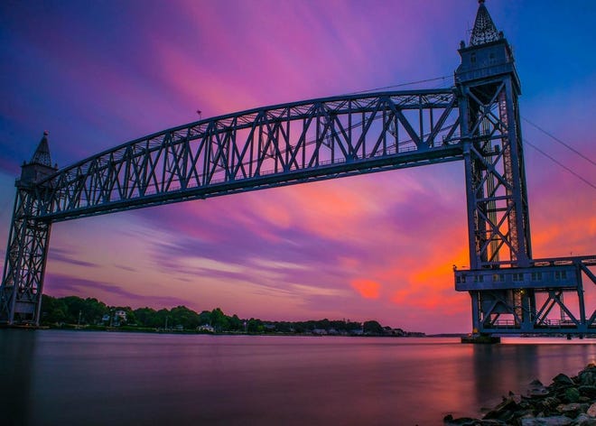 The Cape Cod Canal Railroad bridge under a pink and purple sunset sky.