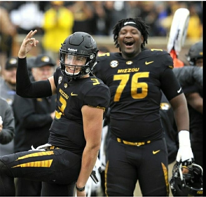 Drew Lock (3) and Tyler Howell (76) celebrate a touchdown by Larry Rountree III in the second quarter against Florida on Saturday.