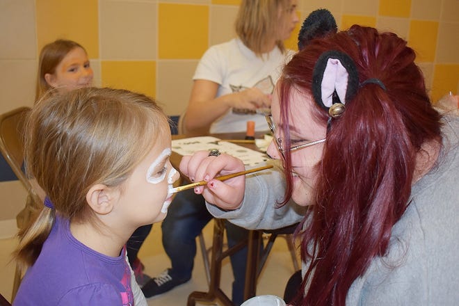 Herkimer-Fulton-Hamilton-Otsego BOCES visual communications media arts senior Sierra Gonzalez, of Frankfort-Schuyler, paints the face of Savannah Grisham, 6, of Utica, during the first Herkimer BOCES Spooktacular Vendor Bazaar on Oct. 29 at the Remington school building in Ilion. [SUBMITTED PHOTO]