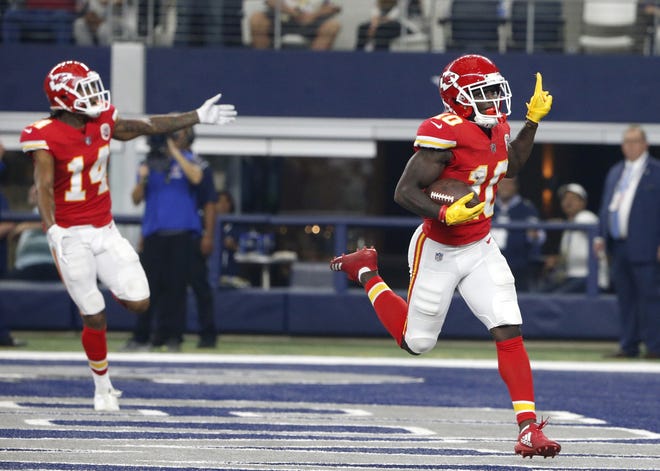 Kansas City's Demarcus Robinson (14) and Tyreek Hill (10) celebrate a long touchdown run by Hill late in the first half. [Michael Ainsworth/The Associated Press]