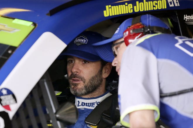 Jimmie Johnson, left, talks to a crew member in the garage during a practice session for Sunday's race at Texas Motor Speedway in Fort Worth. [LM Otero/Associated Press]