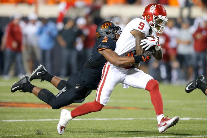 Oklahoma State's Jerel Morrow (5) brings down Oklahoma's CeeDee Lamb (9) during the Bedlam college football game between the Oklahoma State Cowboys (OSU) and the Oklahoma Sooners (OU) at Boone Pickens Stadium in Stillwater, Okla., Saturday, Nov. 4, 2017. Oklahoma won 62-52. Photo by Bryan Terry, The Oklahoman