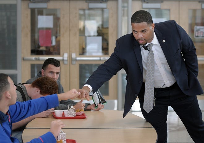 Southbridge High School Principal Andrae Townsel greets students in the cafeteria with a fist bump Thursday. [T&G Staff/Rick Cinclair]