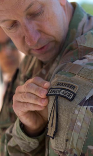 In this Oct. 17, 2017, photo, U.S. Army Col. Scott Jackson shows the patch for the Army's new Security Force Assistance Brigade as they train at Ft. Benning in Columbus, Ga. Jackson commands the brigade that is scheduled to deploy to Afghanistan next year to help train and advise Afghan forces. The Armyâ€™s new training brigade is looking beyond traditional best practices to see if soldiers meet the cultural and personality criteria to train local forces in dramatically different cultures. (AP Photo/John Bazemore)