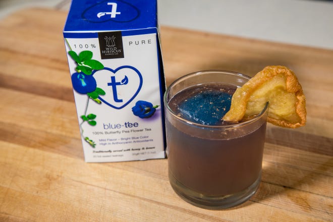 Jonathan Pogash, the "Cocktail Guru," has devised the Season Changer, a blend of peach vodka, almond liqueur, apple cider, Prosecco, lime juice and more — with blue ice made with butterfly-pea flower tea. [The Providence Journal / Sandor Bodo]