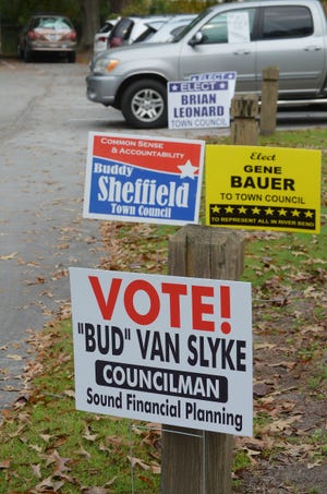Signs line the parking lot of River Bend Town Hall Tuesday morning as residents turn out for the town's municipal elections. [TODD WETHERINGTON / SUN JOURNAL STAFF]