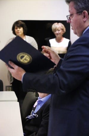 TIMES-REPORTER PAT BURK

Tuscarawas County Prosecutor Ryan Styer reads a proclamation from Ohio Attorney General Mike DeWine to the Mineral City Warrior, (lower left) an 11 year-old boy who was attacked and beaten in 2016, Monday night at the Tuscarawas County SheriffþÄôs Office in New Philadelphia.