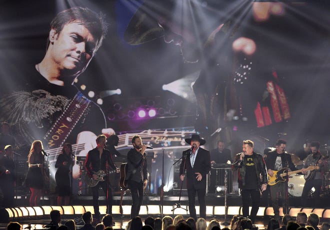 Joe Don Rooney, from left, Dierks Bentley, Eddie Montgomery, Gary LeVox, and Jay DeMarcus perform "My Town" during a tribute to Troy Gentry at the 51st annual CMA Awards at the Bridgestone Arena on Wednesday, Nov. 8, 2017, in Nashville, Tenn. [Photo by Chris Pizzello/Invision/AP]