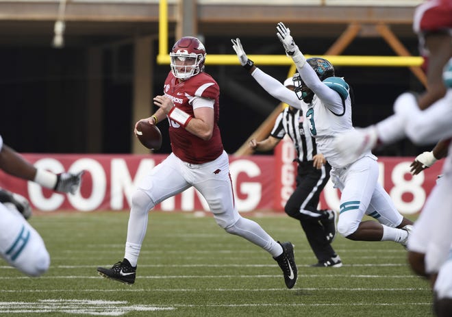 Arkansas quarterback Cole Kelley scrambles out f the pocket as Costal Carolina defender Marcus Williamson puts on the pressure during the first half Saturday, Nov. 4, 2017, in Fayetteville. [AP Photo/Michael Woods]