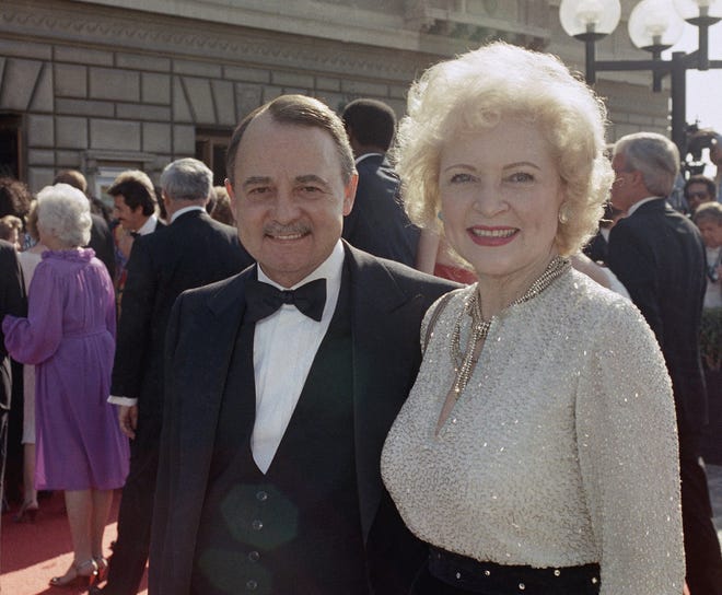 John Hillerman, left, and Betty White, right, arriving at Emmy Awards in Pasadena, California, on Sept. 22, 1985. [AP Photo/LIU, File]