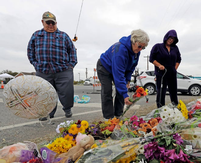 Barbara Solano, center, places flowers at a makeshift memorial for the victims of the First Baptist Church shooting Thursday, Nov. 9, 2017, in Sutherland Springs, Texas. A man opened fire inside the church in the small South Texas community on Sunday, killing more than two dozen and injuring others. (AP Photo/David J. Phillip)