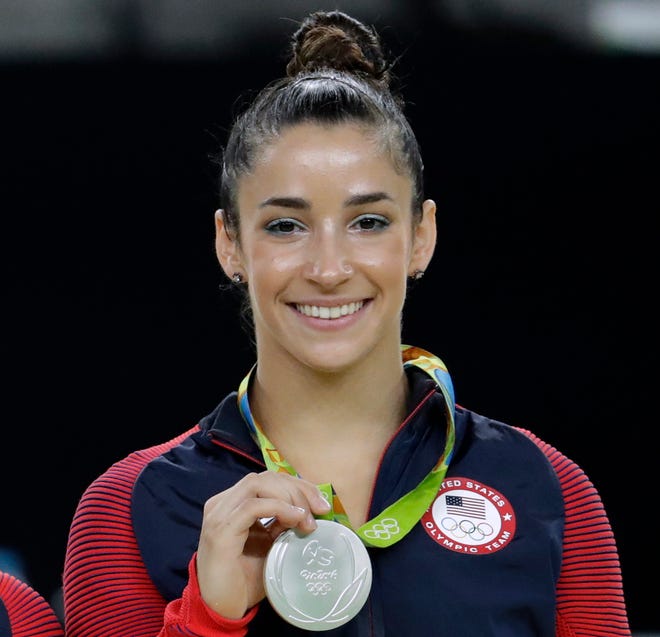 FILE - In this Aug. 16, 2016, file photo, United States' Aly Raisman shows off her silver medal after the artistic gymnastics women's apparatus final at the 2016 Summer Olympics in Rio de Janeiro, Brazil. Six-time Olympic medal winning gymnast Aly Raisman says she is among the young women abused by a former USA Gymnastics team doctor. Raisman tells â€œ60 Minutesâ€ she was 15 when she was first treated by Dr. Larry Nassar, who spent more than two decades working with athletes at USA Gymnastics but now is in jail in Michigan awaiting sentencing after pleading guilty to possession of child pornography. (AP Photo/Dmitri Lovetsky, FIle)