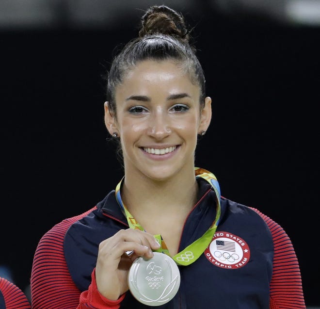 FILE - In this Aug. 16, 2016, file photo, United States' Aly Raisman shows off her silver medal after the artistic gymnastics women's apparatus final at the 2016 Summer Olympics in Rio de Janeiro, Brazil. Six-time Olympic medal winning gymnast Aly Raisman says she is among the young women abused by a former USA Gymnastics team doctor. Raisman tells þÄú60 MinutesþÄù she was 15 when she was first treated by Dr. Larry Nassar, who spent more than two decades working with athletes at USA Gymnastics but now is in jail in Michigan awaiting sentencing after pleading guilty to possession of child pornography. (AP Photo/Dmitri Lovetsky, FIle)