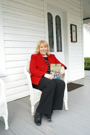 Doris Bloodsworth relaxing on the porch of the Kern House in the Clermont Historic Village. She is holding a copy of her most recent book, "Legendary Locals of Lake County." Doris Bloodsworth is the 2017 inductee of the Lake County Women’s Hall of Fame. [LINDA CHARLTON / CORRESPONDENT]