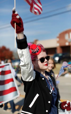 A girl waves an American flag while marching in the Midwest City Veterans Day Parade. [PHOTO BY JIM BECKEL, THE OKLAHOMAN]
