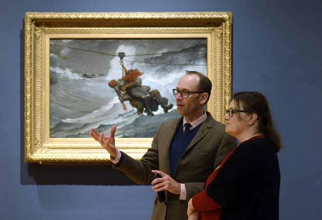 Brandon Ruud and Amanda C. Peterson, both from the Milwaukee Art Museum, walk through the preview of the Winslow Homer exhibit at the Worcester Art Museum Wednesday. Behind them is Homer's "The Life Line" (1884, Philadelphia Museum of Art). [T&G Staff/Rick Cinclair]