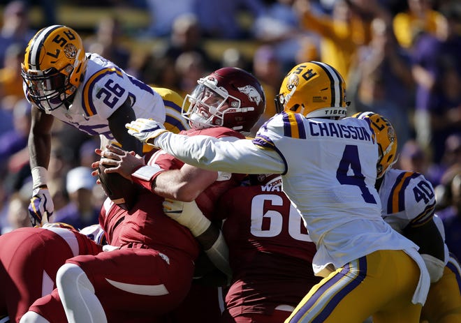 Arkansas quarterback Cole Kelley is stopped short on fourth down by LSU linebackers K'Lavon Chaisson (4), Devin White (40) and safety John Battle (26) in the second half of Saturday’s game in Baton Rouge. [Gerald Herbert/The Associated Press]