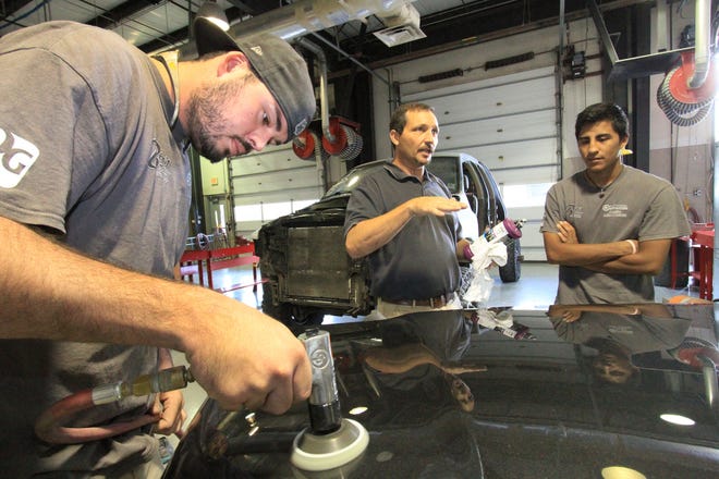 Gene Deyo, center, program manager in the collision repair classes at Daytona State College Advanced Technology Center works with students Mike Marz, left, buffing out a repair on a freshly painted truck hood, and Carlos Barrera, in 2015. The center was among recipients of state funds in the 2017-18 budget. [News-Journal/David Tucker]