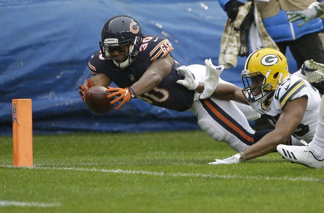 Chicago Bears running back Benny Cunningham dives to the end zone against Green Bay Packers defensive back Marwin Evans as Cunningham fumbles the ball during the first half on Sunday in Chicago. [NAM Y. HUH/THE ASSOCIATED PRESS]