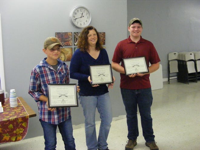 From left: Thomas Grady III for his third place win in the novice division, Coach Angie Cox for all members of the trap league's third-place win and Hunter Crofoot for his third place win in the JV division.