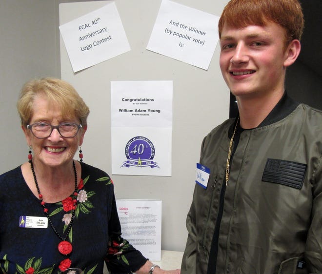 Unveiled as the people's choice selection, Flagler County Art League president Ann DeLucia congratulates logo contest winner William Adam Young, a Flagler Palm Coast High School junior, during the opening of "Celebrate Flagler County" on Saturday. [News-Tribune photos/Danielle Anderson]