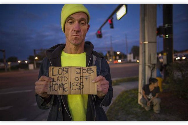 Ryan Hoffman with a panhandling sign and his girlfriend Michelle Pettigrew, in background, at a busy intersection in Lakeland, Fla., Jan. 7, 2015. Hoffman, once a 287-pound starting left tackle for a top-ten ranked University of North Carolina football team, renowned for his toughness and durability, was now plagued with short-term memory problems and lived on the street, sometimes begging money from passing cars Hoffman passed away on Nov. 16, 2015, when a car that hit and killed Hoffman as he drove his bike into oncoming traffic. Representatives of Hoffman's estate brought a lawsuit against the ACC and NCAA on Wednesday.