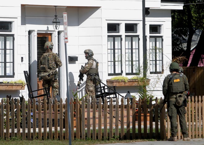 An FBI unit dressed in military uniforms joins the investigation on a fatal shooting in the Seminole Heights neighborhood in Tampa, Fla., Tuesday, Nov. 14, 2017. Police and federal agents with rifles checked car trunks, banged on doors and gathered forensic evidence in the neighborhood Tuesday as they hunted for the killer believed responsible for gunning down several people for no apparent reason in just over a month. (Octavio Jones/Tampa Bay Times via AP)
