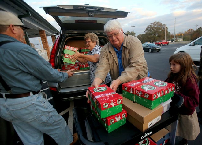 Volunteers unload a car full of Operation Christmas Child boxes at Bethel Baptist Church on Tuesday. [Brittany Randolph/The Star]