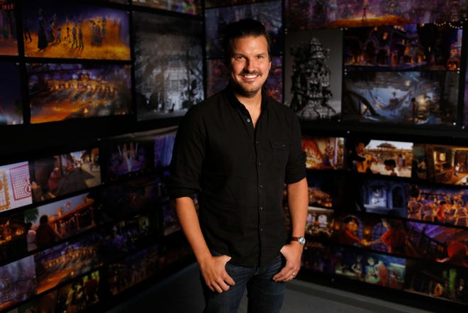 Dean Kelly poses in front of a wall of drawings from “Coco.” [Disney/Pixar]
