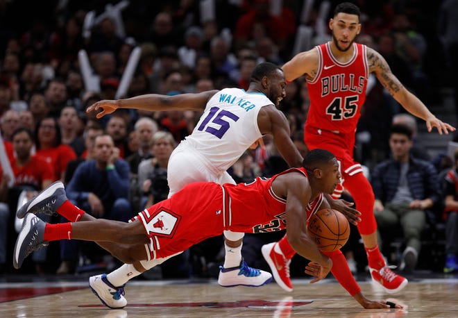 Chicago Bulls' Kris Dunn dives for the ball against Charlotte Hornets' Kemba Walker (15) as Bulls' Denzel Valentine (45) looks on during the second half of an NBA basketball game Friday, Nov. 17, 2017, in Chicago. (AP Photo/Jim Young)