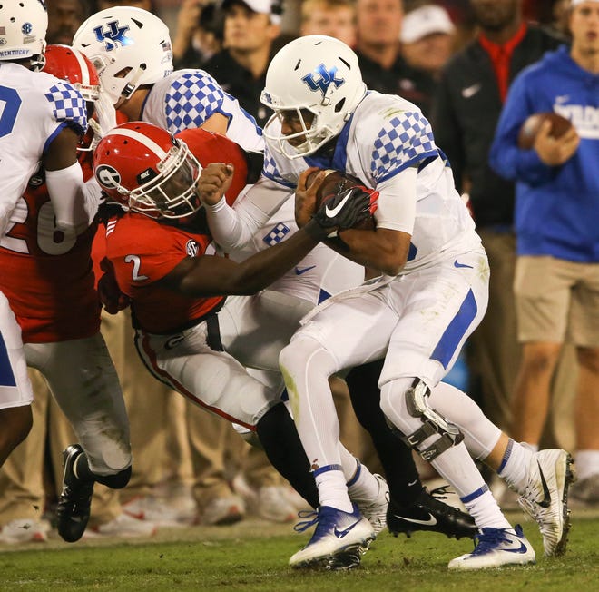 Kentucky quarterback Stephen Johnson (15) is stopped by Georgia defensive back Richard LeCounte III (2) after a short gain in the second half of an NCAA college football game Saturday, Nov. 18, 2017, in Athens, Ga. Georgia won 42-13. (AP Photo/John Bazemore)