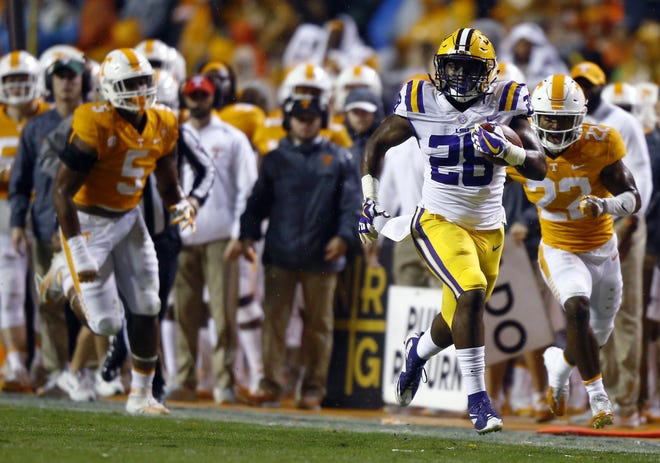 LSU running back Darrel Williams (28) runs as Tennessee defensive back Micah Abernathy (22) gives chase during Saturday's game in Knoxville, Tenn. [Wade Payne/The Associated Press]