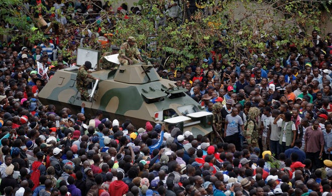 An army armored personnel carrier drives slowly through the gathered crowd of thousands demanding President Robert Mugabe stand down, on the road leading to State House in Harare, Zimbabwe Saturday, Nov. 18, 2017. In a euphoric gathering that just days ago would have drawn a police crackdown, crowds marched through Zimbabwe's capital on Saturday to demand the departure of President Robert Mugabe, one of Africa's last remaining liberation leaders, after nearly four decades in power. (AP Photo/Ben Curtis)