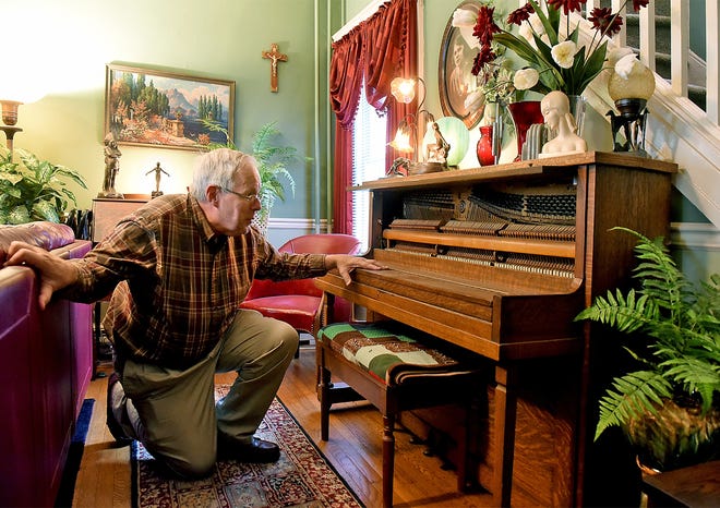 Harry Heck, of Burlington City, checks his 1930s-era Miessner oak piano. [NANCY ROKOS / STAFF PHOTOJOURNALIST]