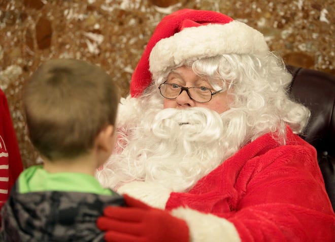 Santa Claus, also known as Tom White, chated with a boy who stopped by with his Christmas wish list at the Lions Lincoln Theatre in December 2016. (IndeOnline.com / Kevin Whitlock)