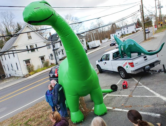 Locals get an opportunity to get their picture taken at Newmarket Sinclair gas station with DINO, the mascot for Sinclair Oil that will be in the Macy's Thanksgiving Day Parade in New York City. [John Huff/Fosters.com]