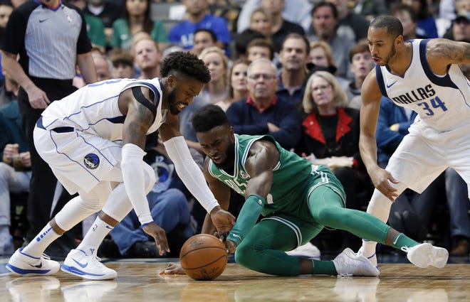 Mavericks guard Wesley Matthews (23) and Boston's Jaylen Brown scramble on the floor for a loose ball as Devin Harris (34) looks on during Monday's game in Dallas. The Celtics rallied for a 110-102 win in overtime for their 16th consecutive win.
[Tony Gutierrez/AP]