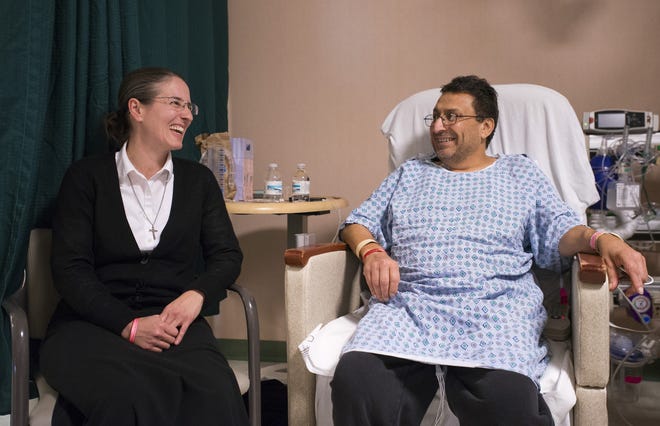 Tresa Van Heusen, left, of Beaver Falls, shares a laugh with Patrick Michael, of Center Township, during a visit Monday at Michael's room at Allegheny General Hospital in Pittsburgh. Michael received a kidney as a result of a paired exchange in which Van Heusen agreed to donate her kidney to another patient. Van Heusen and Michael attend church together at Theresa of Calcutta Maronite Catholic Church. [Kevin Lorenzi/BCT staff}
