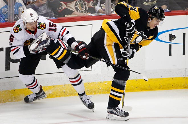 Pittsburgh Penguins' Evgeni Malkin (71) loses control of the puck as he collides with Chicago Blackhawks' Artem Anisimov (15) Saturday. Malkin will miss at least one game with an undisclosed injury. [AP Photo/Gene J. Puskar]