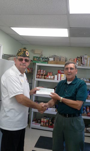 Amvets Post 2 Edgewater donated nonperishables Nov. 13 to the FGCC Community Resource Center food pantry. From left, Cmdr. Melvin Lane presented the Rev. Charles Vanorsdale with a $1,000 check. The pantry also had its free food distribution the same day for 395 families. [Photo provided]