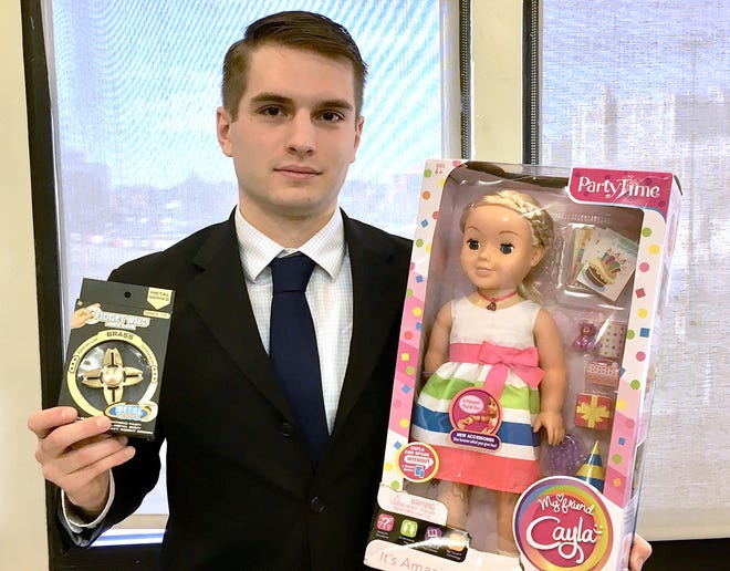 Evan Gaudette of MASSPIRG shows potentially hazardous toys, including the "My Friend Cayla" doll. [T&G Staff/Craig Semon]