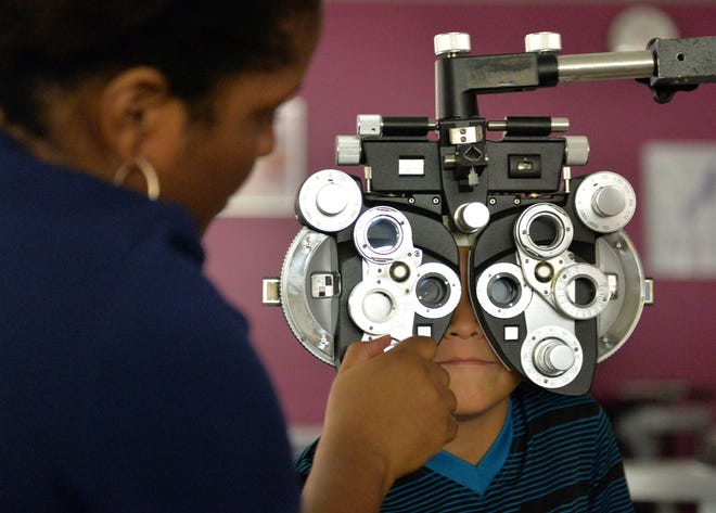 Armando Gonzalez of Palmetto gets his eyes checked at the Remote Area Medical clinic last year at Manatee Technical College. The free clinic offers medical exams, dental care, eye exams. etc., for the low-income and uninsured. [Herald-Tribune staff photo / Mike Lang]