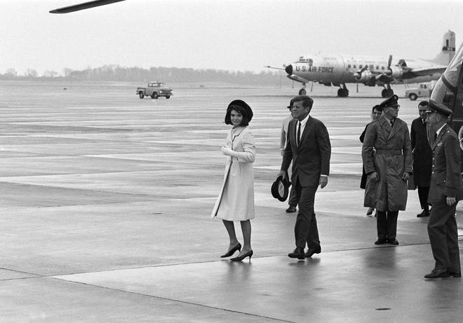 President John F. Kennedy and first lady Jacqueline Kennedy walk through the rain at Andrews Air Force Base in Maryland, Nov. 21, 1963, to board the presidential jet for a flight to San Antonio, Texas. The president and his wife plan to spend two days in Texas. (AP Photo/John Rous)