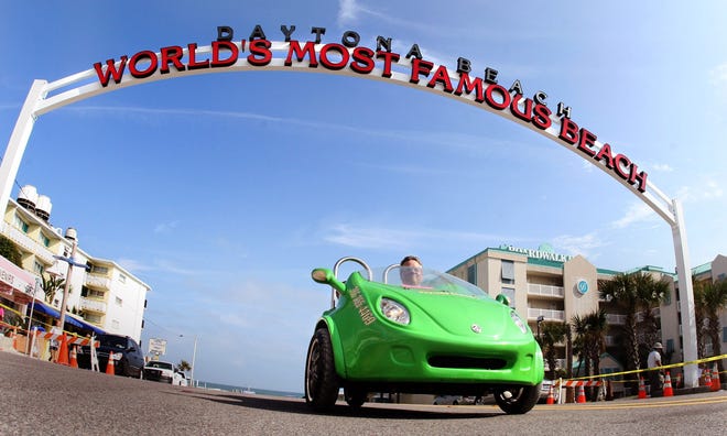 A rental car passes under the World's Most Famous Beach sign at the Broadway Approach. [News-Journal/JIM TILLER]