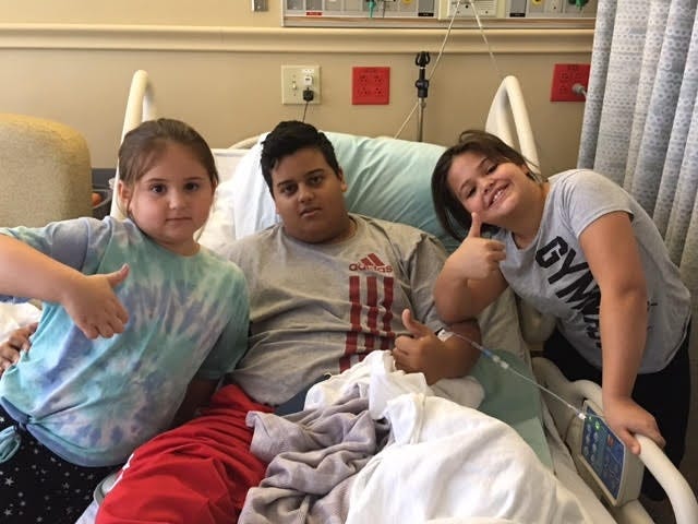 Former Vanguard High School student and football player Nico Rivera was flanked during a recent hospital by his sisters Hannah Berry and Catherine Berry. Rivera, 18, has Alport syndrome, a disease of the kidneys, and his family is working to find a potential organ donor. [Photo courtesy Jill Brannen]
