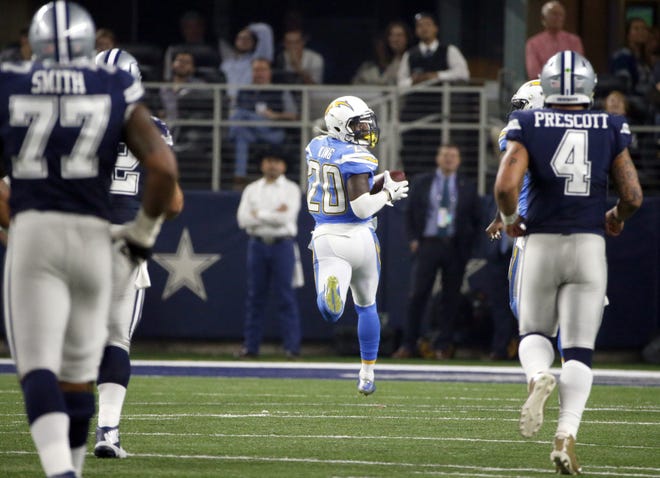 Dallas Cowboys' Tyron Smith (77) and quarterback Dak Prescott (4) watch as Los Angeles Chargers cornerback Desmond King (20) returns an interception for a touchdown in the second half Thursday in Arlington, Texas. [The Associated Press / Michael Ainsworth]