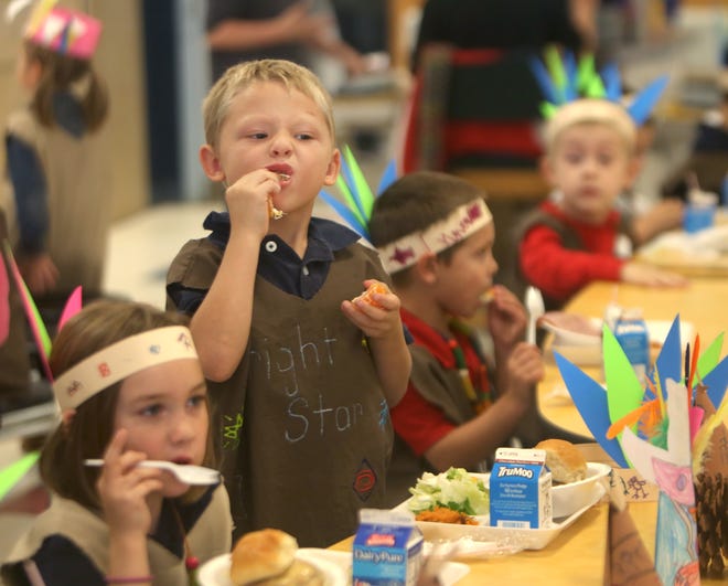 T.J. Crowley bites into an orange during Thanksgiving brunch at Deane Bozeman School on Nov. 16. The students dressed as pilgrims and Native Americans and decorated the cafeteria themselves. Go to newsherald.com for a related video and gallery. [PATTI BLAKE/THE NEWS HERALD]