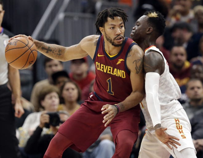 Cleveland Cavaliers' Derrick Rose, left, drive against Atlanta Hawks' Dennis Schroder (17), from Germany, in the first half of an NBA basketball game, Sunday, Nov. 5, 2017, in Cleveland. (AP Photo/Tony Dejak)