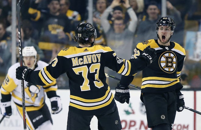 The Bruins' Sean Kuraly (52) celebrates his goal with teammate Charlie McAvoy (73) during the first period Friday in Boston. [Michael Dwyer/The Associated Press]